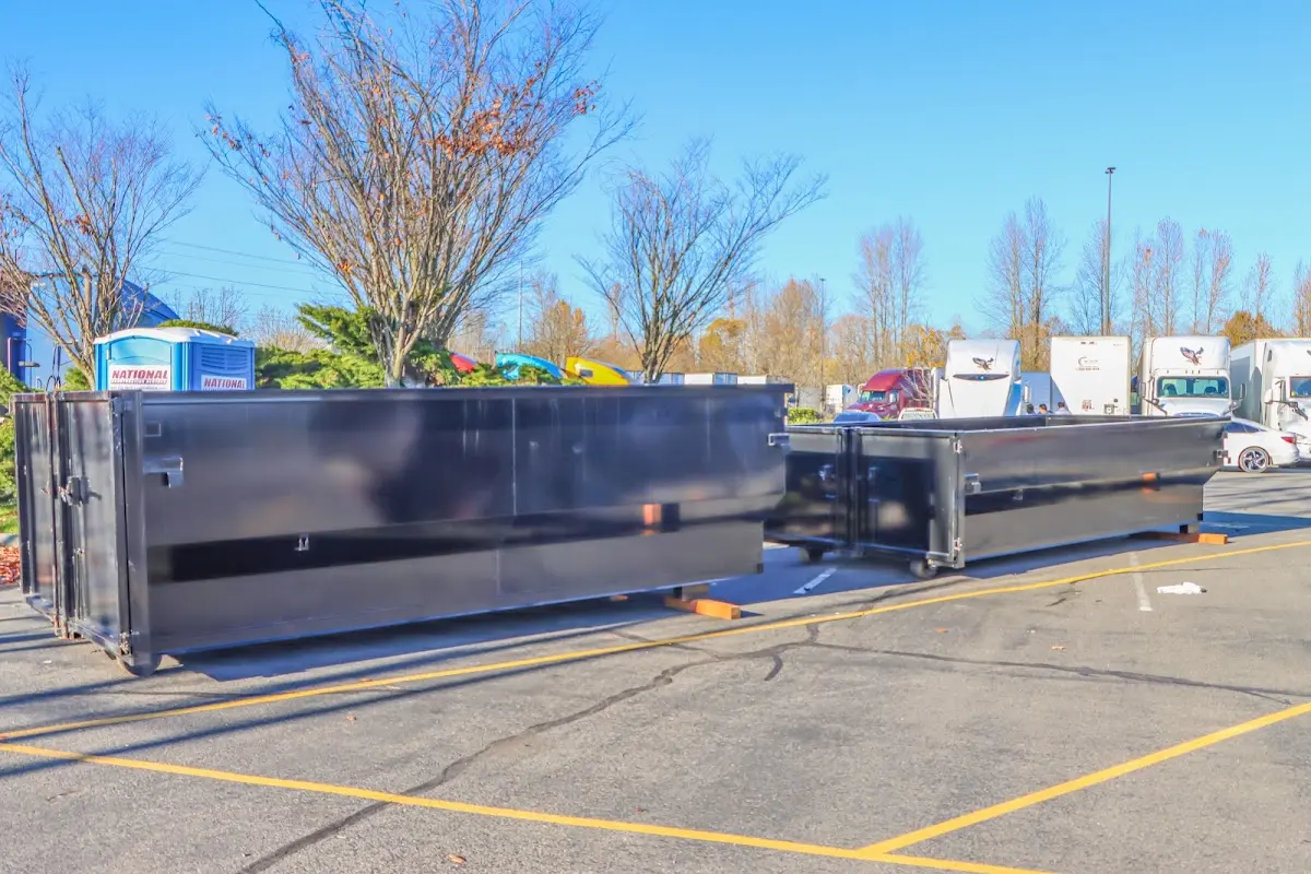 Professional dumpster rental service with roll-off container on residential driveway in Antis